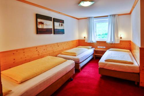 a room with three beds and a window at Alpenhaus Montafon by Pferd auf Wolke in Gargellen