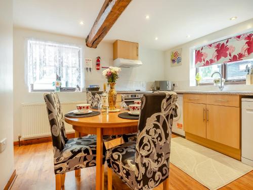 a kitchen with a wooden table and chairs in a kitchen at Pear Tree Cottage in Banham