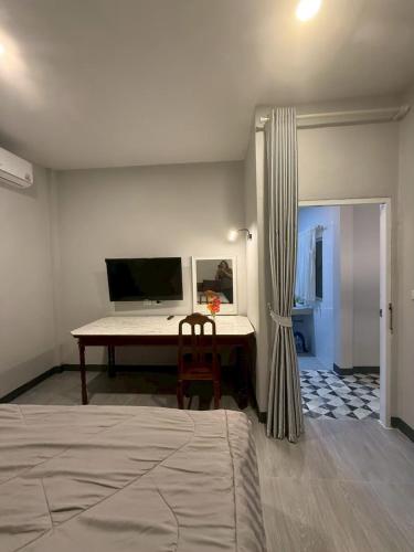 a bedroom with a desk and a bed with a chair at Joyful House in Ban Dan