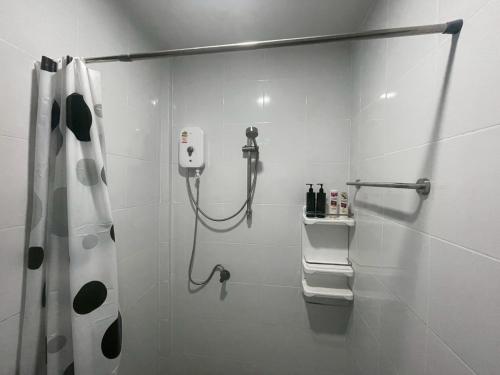 a white bathroom with a shower and a shower curtain at Joyful House in Ban Dan