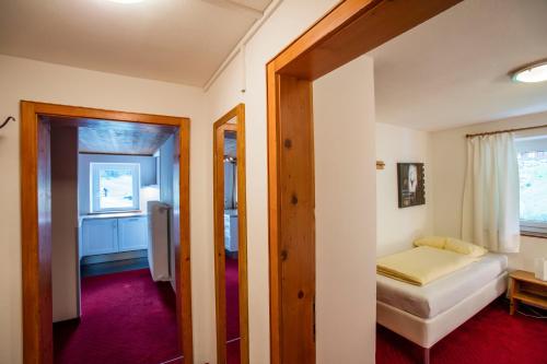 a small room with a bed and a mirror at Alpenhaus Montafon by Pferd auf Wolke in Gargellen