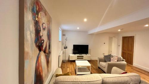 a living room with a couch and a tv at Flat 1- The Marilyn in Banbury