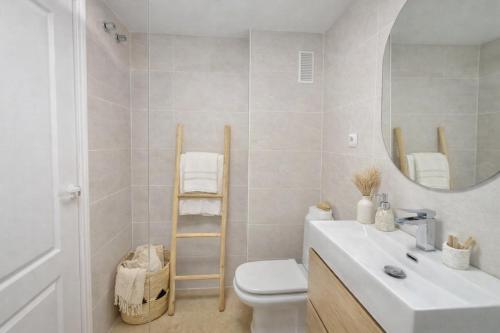 a bathroom with a sink and a toilet and a mirror at Noctua Duquesa Beach 009 in Manilva