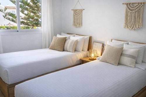 two beds in a room with two windows at Noctua Duquesa Beach 009 in Manilva