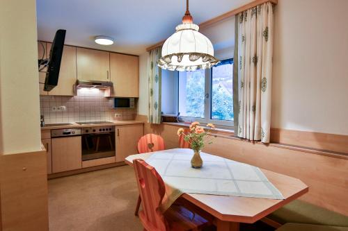 a kitchen with a table with a vase of flowers on it at Alpenhaus Montafon by Pferd auf Wolke in Gargellen