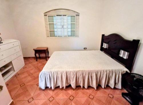 a bedroom with a bed and a dresser and a window at Espaço da Iza in São Pedro