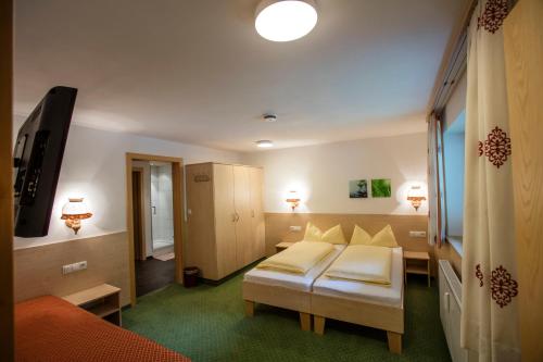 a hotel room with two beds and a tv at Alpenhaus Montafon by Pferd auf Wolke in Gargellen