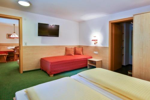 a hotel room with two beds and a table at Alpenhaus Montafon by Pferd auf Wolke in Gargellen