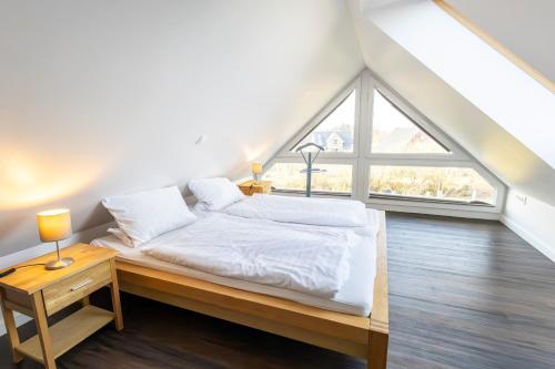 a bedroom with a bed and a large window at Doppelhaushälfte Op de Geest in Böhl