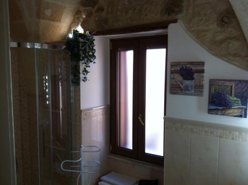 een badkamer met een douche, een toilet en een raam bij Porta Piccola B&B in Mesagne