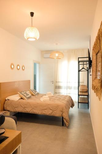 a bedroom with a large bed and two chandeliers at Saludu Boutique in Porto Torres