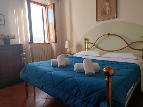 a bedroom with a blue bed with two pillows at Casa dell' Onda 25 in Siena