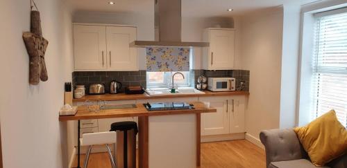 a kitchen with white cabinets and a counter top at Flat 11- The Orchid in Banbury