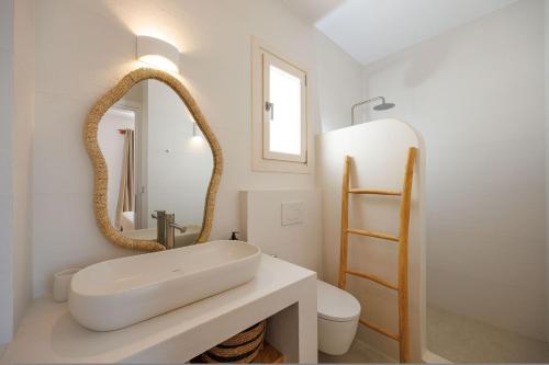 a white bathroom with a sink and a mirror at Arcadia Naxos in Naxos Chora