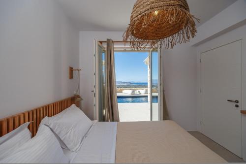 a bedroom with a bed with a view of the ocean at Arcadia Naxos in Naxos Chora