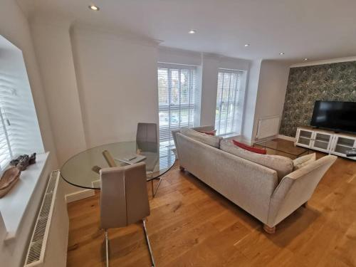 a living room with a couch and a glass table at Flat 12- The Meadow in Banbury