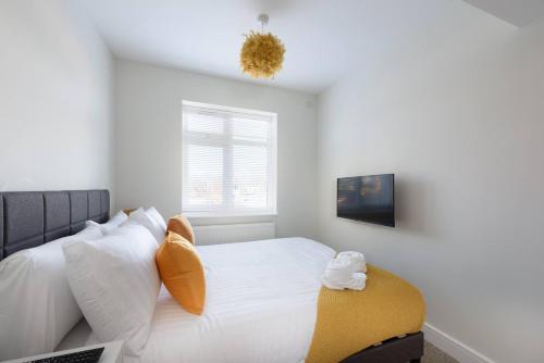 a bedroom with a bed with white pillows and a window at Perfect 3 Bedroom Accommodation for Contractors! in Banbury