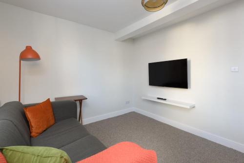 a living room with a couch and a flat screen tv at Perfect 3 Bedroom Accommodation for Contractors! in Banbury