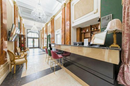 a lobby with a bar and chairs in a building at Hotel Praga 1885 by Wagnerstays in Prague