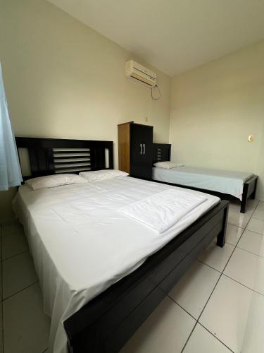 a bedroom with two beds with white sheets at Hotel Brilhante 2 in Itacarambi