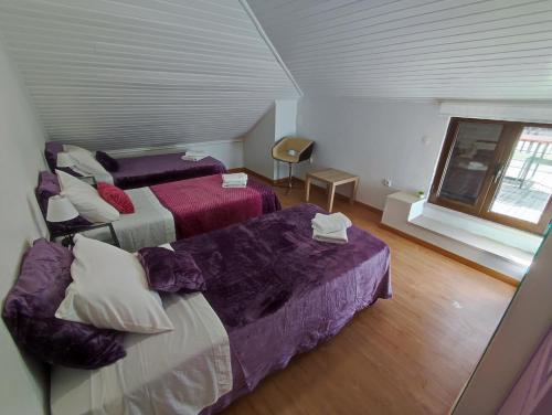 a room with two beds and a couch and a window at Alenquer, Alojamento Santa Catarina in Alenquer