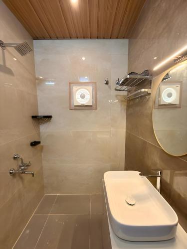 a bathroom with a toilet and a sink and a mirror at Evara Stays Coorg in Kushālnagar