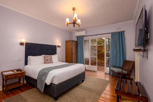Argyll Guest House في هراري: غرفة نوم بها سرير كبير وتلفزيون