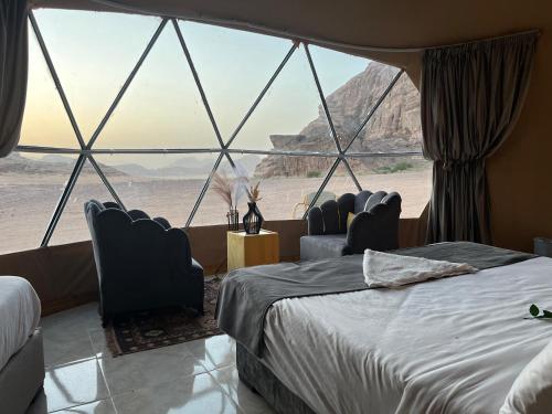 a room with two beds and a view of the desert at Lawrence Luxury Camp in Wadi Rum
