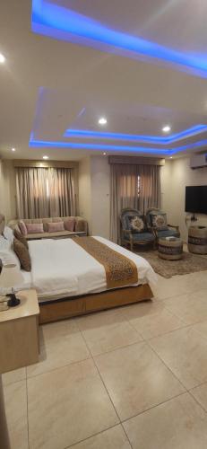 a large bedroom with a large bed and a blue light at عمارة النفيسة السكنية in Unayzah
