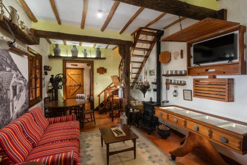 a living room with a couch and a flat screen tv at Antiga Fábrica da Manteiga by An Island Apart in Arco da Calheta