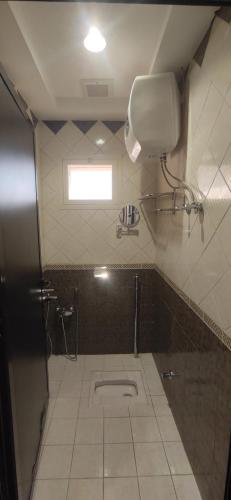 a small bathroom with a toilet and a window at عمارة النفيسة السكنية in Unayzah