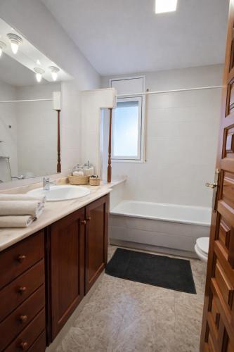 a bathroom with a sink and a bath tub at Villa Xaloc piscine privée in Les tres Cales