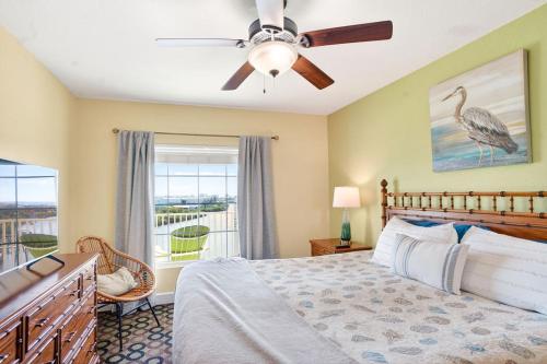 a bedroom with a bed with a ceiling fan and a window at Splash Harbour, Harbourside Waterfront Condo in Clearwater Beach