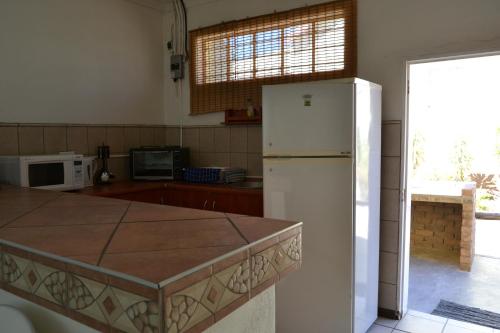 a kitchen with a white refrigerator and a counter at Kenhardt Hotel in Kenhardt