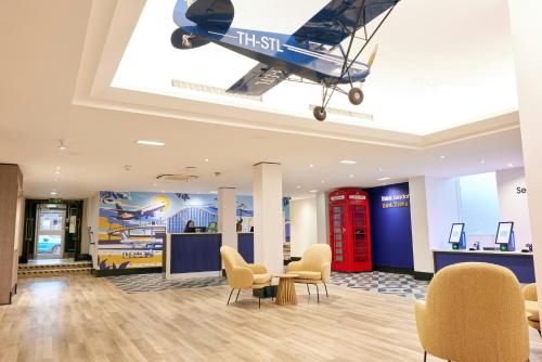 a plane hanging from the ceiling in a waiting room at Thistle London Heathrow Terminal 5 in Hillingdon