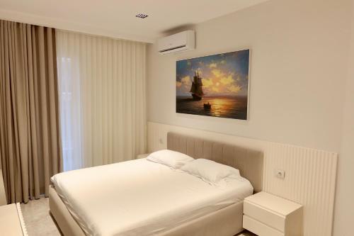 a bedroom with a bed and a painting on the wall at Ilyonis Residence apartment luxury in Shëngjin