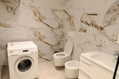 a bathroom with a washing machine and a toilet at Ilyonis Residence apartment luxury in Shëngjin