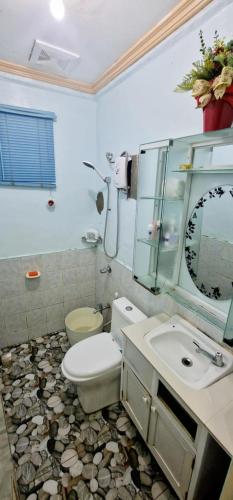 a bathroom with a toilet and a sink and a mirror at M & D Rentals by Jick in Butuan
