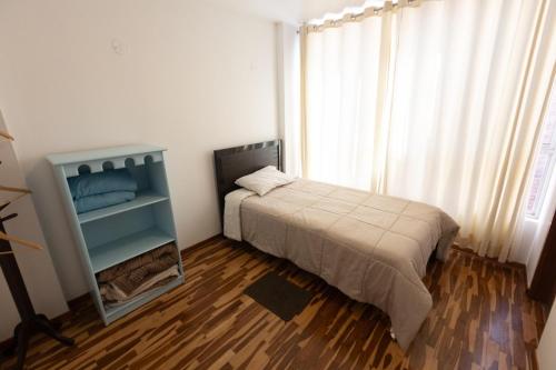 a small bedroom with a bed and a window at Casa completa, 5 dormitorios y jardín in Ayacucho