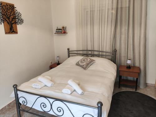 a bed with towels on it in a bedroom at A & P Apartment in Xanthi