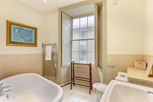ein Badezimmer mit Badewanne, Waschbecken und Fenster in der Unterkunft 2 Bed in Alnwick oc-f28915 in Alnwick