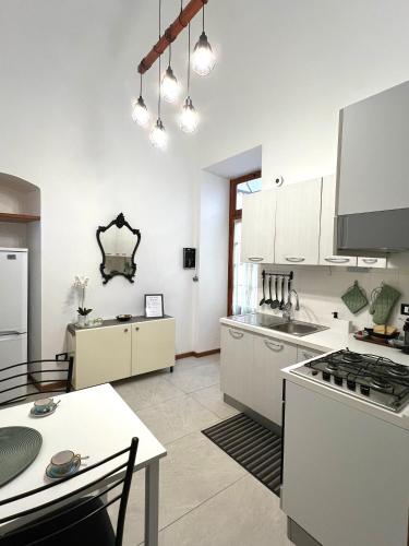 a large kitchen with white cabinets and a table at Porto Vecchio Apartment in Sanremo