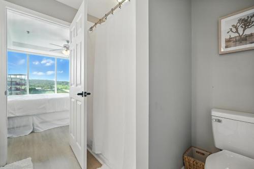a white bathroom with a toilet and a window at New 2 Bed 2 Bath Condo with Pool at BMS in Bristol