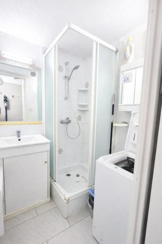 a white bathroom with a shower and a sink at LES MARINES 2 - Villa en résidence avec piscine à 2 pas de la plage - Clim - parking in Saint-Cyprien