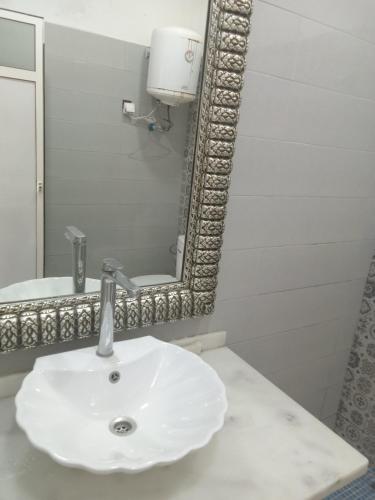 a bathroom with a white sink and a mirror at Suite in nice résidence in Rabat