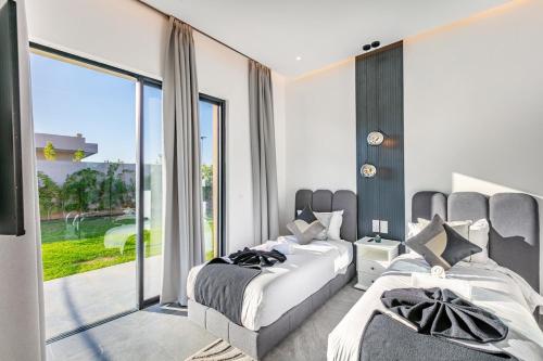 a bedroom with two beds and a large window at Villa Prestige Privée avec Vue Splendide in Marrakesh