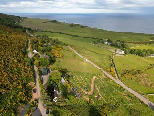an aerial view of a green field with the ocean at Lothmore Lookout - Sunrise in Kilmote