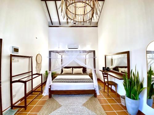 a bedroom with a bed and a chandelier at MAYA Ahangama in Ahangama