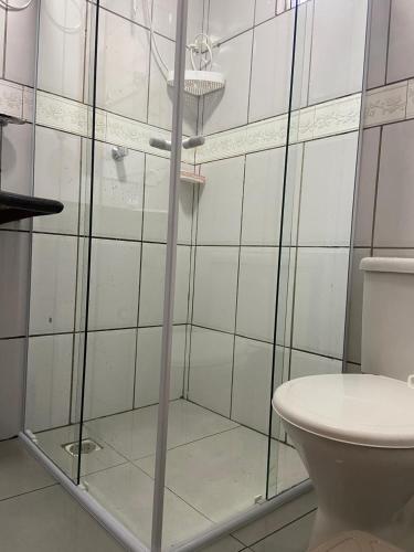 a bathroom with a glass shower with a toilet at Apto 013 - Residencial Canaã in Porto Velho
