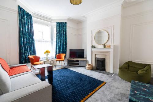 a living room with a couch and a fireplace at Spacious Victorian for 10 across Royal Infirmary in Leicester